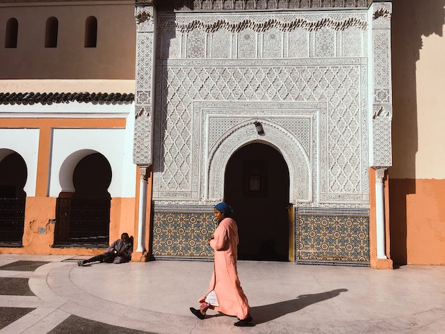 Meningkatkan kualitas ibadah: Person Walking Beside Mosque