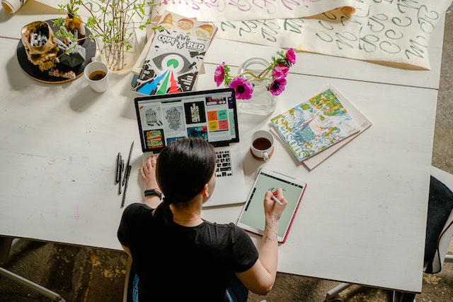 Strategi email marketing: Photo of Woman Writing on Tablet Computer While Using Laptop