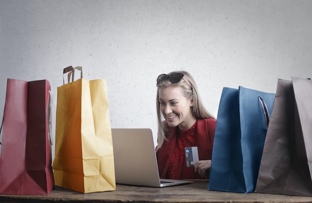 kartu kredit dan kartu debit: Happy woman shopping online at home