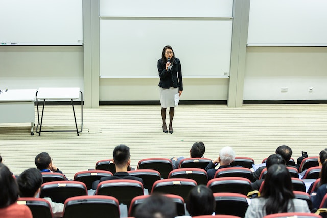 Mahasiswa baru: Woman Holding Microphone Standing in Front of Crowd