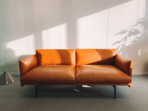 Desain apartemen minimalis: 2-seat Orange Leather Sofa Beside Wall