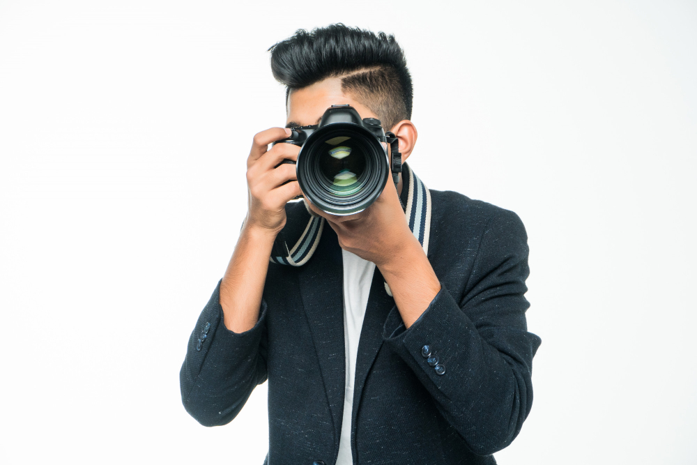 young asian man with camera isolated white background photographer concept